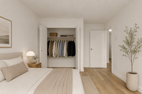 Surrey apartment for rent - A bedroom with a large bed and a closet with clothes hanging.