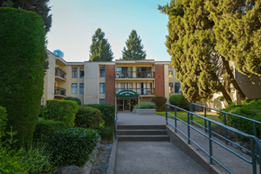 Surrey apartment for rent - A building with a green lawn in front.