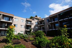 New Westminster apartment for rent - Apartment complex with a garden in the front.