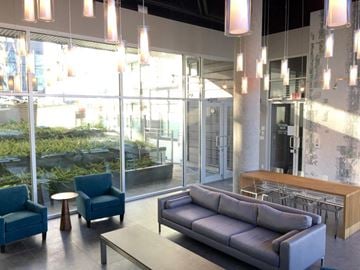 Vancouver apartment for rent - A modern living room with a grey sofa and blue chairs.