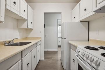 Surrey apartment for rent - A kitchen with white cabinets and a white stove.