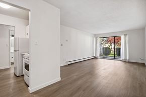 Surrey apartment for rent - A spacious, empty room with wooden floors and white walls.