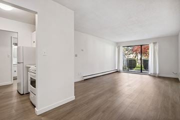 Surrey apartment for rent - A spacious, empty room with wooden floors and white walls.