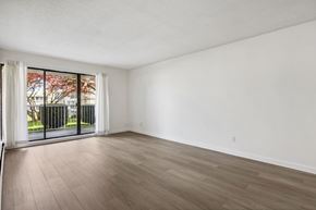 Surrey apartment for rent - A room with a sliding glass door and wood flooring.