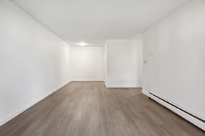 Surrey apartment for rent - A room with wooden flooring and white walls.