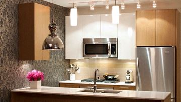 Richmond apartment for rent - A modern kitchen with a stainless steel refrigerator and a microwave above the stove.