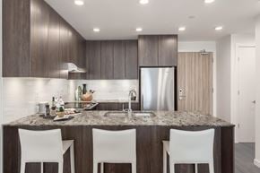 North Vancouver apartment for rent - a kitchen with a granite counter top and a stainless steel refrigerator
