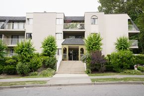 Burnaby apartment for rent - A building with a grey facade and a green lawn in front.