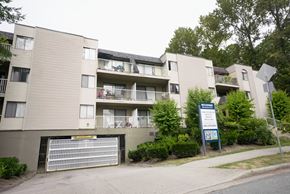 Burnaby apartment for rent - Apartment complex with a sign in front of it.