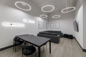 Vancouver apartment for rent - A modern conference room with a long table, chairs, and framed pictures on the wall.