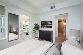 Los Angeles apartment for rent - A modern bedroom with a large bed and a flat screen TV mounted above a fireplace. at SMB Hollywood Apartments, Los Angeles, 90038