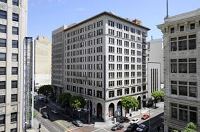 Los Angeles apartment for rent - A street view of a city with a large building in the middle.
