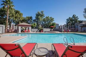 Phoenix apartment for rent - A pool area with red lounge chairs and a gazebo.