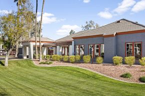Phoenix apartment for rent - A building with a grey roof and a green lawn in front.