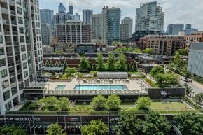 Chicago apartment for rent - A view of a cityscape with a pool and apartment buildings.