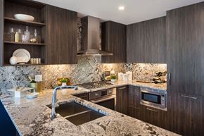 Chicago apartment for rent - A modern kitchen with dark wood cabinets and a marble countertop.