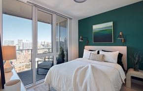 Chicago apartment for rent - a bedroom with a bed and a green wall and a balcony