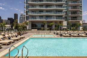 Los Angeles apartment for rent - A large swimming pool in front of a multi-story building.
