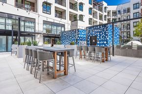 Los Angeles apartment for rent - an outdoor patio with tables and chairs and a building in the background at SMB Hollywood Apartments, Apartments, Los Angeles, CA