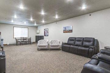 West Fargo apartment for rent - a living room with leather couches and chairs and a dining table