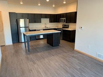 Owatonna apartment for rent - a kitchen with a island and a stainless steel refrigerator