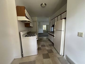 Minneapolis triplex for rent - A kitchen with white appliances and a checkered floor.