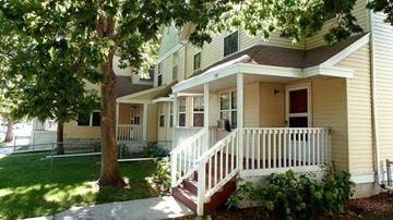 Minneapolis townhouse for rent - a yellow house with a white porch and a tree