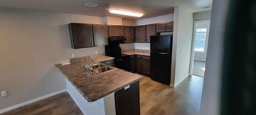 Pine City triplex for rent - a kitchen with black appliances and granite counter tops