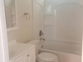 Bremerton apartment for rent - A white toilet sits next to a bathtub in a bathroom.
