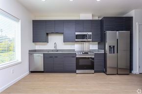 Port Orchard apartment for rent - A modern kitchen with stainless steel appliances and dark grey cabinets. at Plisko Place, Port Orchard