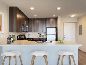 Bremerton townhouse for rent - a kitchen with a counter top with three stools at Spyglass Hill Apartments, Bremerton