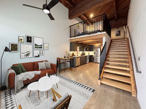 Bremerton apartment for rent - A living room with a couch, a coffee table, and a staircase leading to the upper floor at B Flats Apartments, Bremerton, 98337