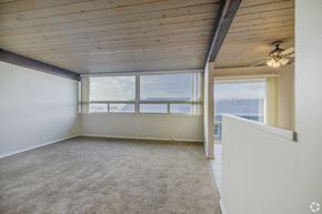 Bremerton apartment for rent - A room with a carpeted floor and a ceiling fan.