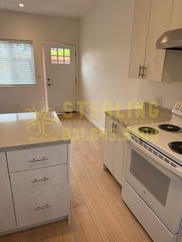 Marina townhouse for rent - A kitchen with white cabinets and a stove top oven.