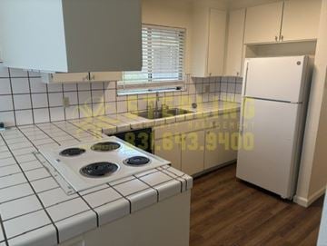 Salinas triplex for rent - A kitchen with a white tiled stove top and a white fridge.