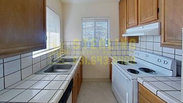 Monterey apartment for rent - A kitchen with a white stove top oven and a white dishwasher.