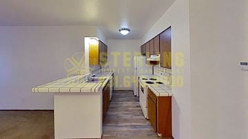 Monterey apartment for rent - A kitchen with a white counter and a brown cabinet.