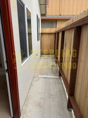 Marina townhouse for rent - A view of a balcony with a red door and wooden fence.