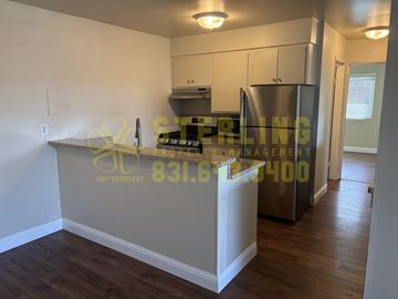 Pacific Grove apartment for rent - A kitchen with a stove top oven and a refrigerator.