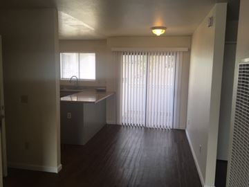 Seaside triplex for rent - A kitchen with a sink and a window with blinds.
