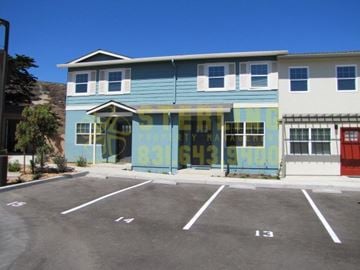 Marina townhouse for rent - A blue and white building with a yellow sign on the front.