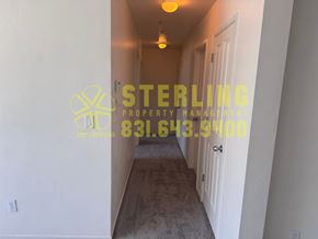 Monterey apartment for rent - A hallway with a Sterling Property Management logo and phone number on the wall.