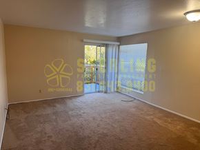 Monterey apartment for rent - A room with a carpeted floor and a wall with a logo and text on it.