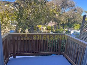 Monterey apartment for rent - A wooden deck with a railing and a view of a backyard.