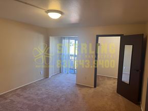 Monterey apartment for rent - A room with a carpet floor and a door leading to a balcony.
