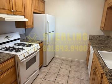 Monterey apartment for rent - A kitchen with a stove, refrigerator, and cabinets.