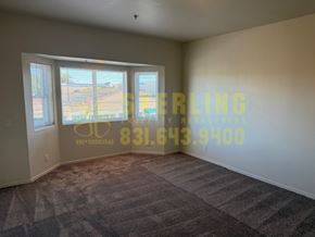 Monterey apartment for rent - A room with a carpeted floor and a wall with a phone number on it.