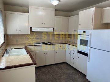 Salinas apartment for rent - A kitchen with white cabinets and a white refrigerator.