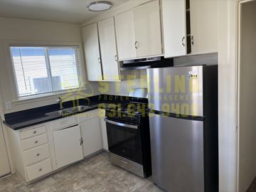 Monterey apartment for rent - A kitchen with a refrigerator, oven, and cabinets.