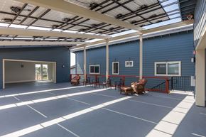 Marina apartment for rent - the courtyard of a blue building with chairs and a bench